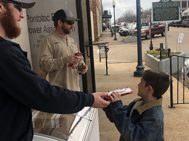 Pontotoc Electric Apprentice Linemen Seth Moss and Walker Westmoreland hand out ice cream during downtown Pontotoc’s Customer Appreciation Day.